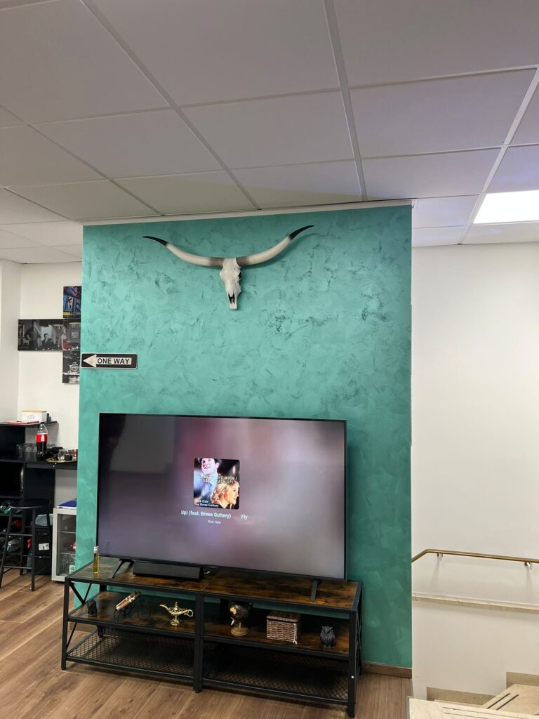 Fertige Akzentwand in Grün mit Metallic-Streichputz im Wartebereich eines Barbershops in München-Gern